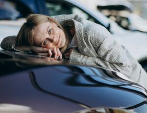 Jeune conductrice devant sa première voiture - Assurance jeune permis MAGA Assurances